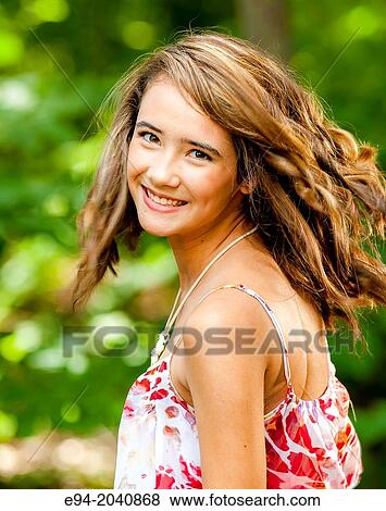 Portrait of a smiling 14 year old brunette girl in a summer dress in an outdoor setting. View Large Photo Image Stock Photo - Portrait of a smiling 14 year old brunette girl in a summer dress in an outdoor setting.. Fotosearch