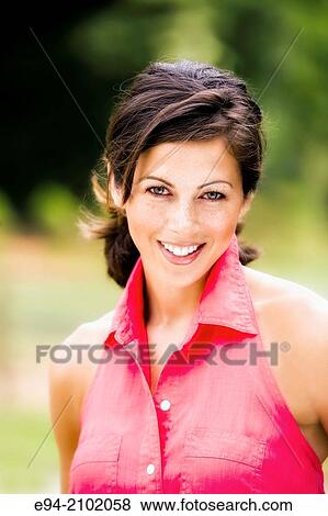 Portrait of a smiling 27 year old brunette woman looking at the camera, outdoors. View Large Photo Image Stock Photo - Portrait of a smiling 27 year old brunette woman looking at the camera, outdoors.. Fotosearch