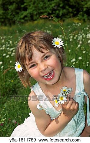 Portrait of a smiling little girl wearing white dress holding daisies View Large Photo Image Stock Photo - Portrait of a smiling little girl wearing white dress holding daisies. Fotosearch