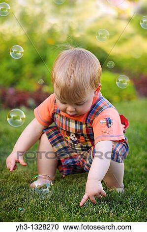 Portrait of a toddler playing with bubbles in the garden View Large Photo Image Stock Image - Portrait of a toddler playing with bubbles in the garden. Fotosearch