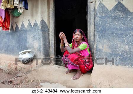 Picture - Portrait of a tribal woman sitting outside her hut. Malhar caste. Kendwatoli village, District Hazaribaug, Jharkhand.. Fotosearch