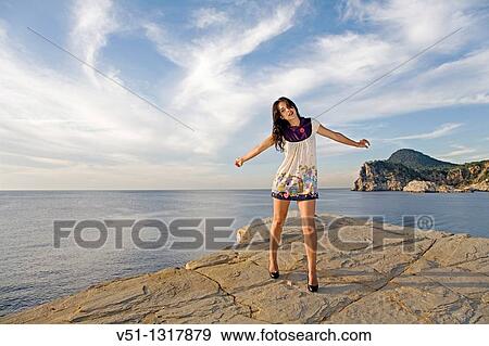 Portrait of a woman in a clifff with high heels in Ibiza View Large Photo Image Stock Photo - Portrait of a woman in a clifff with high heels in Ibiza. Fotosearch