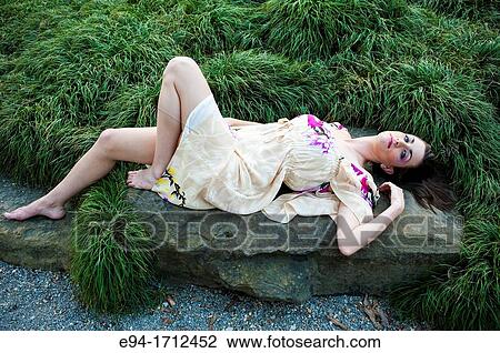 Portrait of a young a 22 year old brunette woman wearing a dress in a garden setting View Large Photo Image Stock Image - Portrait of a young a 22 year old brunette woman wearing a dress in a garden setting. Fotosearch