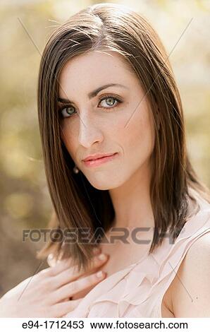 Portrait of a young a 22 year old brunette woman wearing a dress in a garden setting View Large Photo Image Stock Image - Portrait of a young a 22 year old brunette woman wearing a dress in a garden setting. Fotosearch
