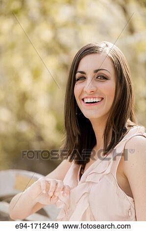 Portrait of a young a 22 year old brunette woman wearing a dress in a garden setting View Large Photo Image Stock Photo - Portrait of a young a 22 year old brunette woman wearing a dress in a garden setting. Fotosearch