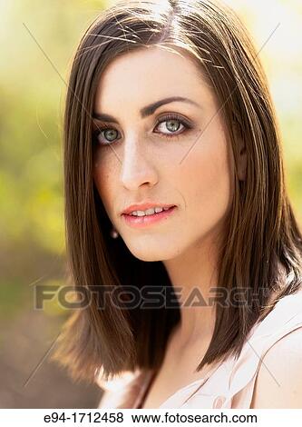 Portrait of a young a 22 year old brunette woman wearing a dress in a garden setting View Large Photo Image Stock Photo - Portrait of a young a 22 year old brunette woman wearing a dress in a garden setting. Fotosearch