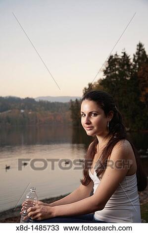 Portrait of a young athletic woman holding a bottle of water, Inlet Park, Port Moody, British Columbia, Canada View Large Photo Image Stock Image - Portrait of a young athletic woman holding a bottle of water, Inlet Park, Port Moody, British Columbia, Canada. Fotosearch