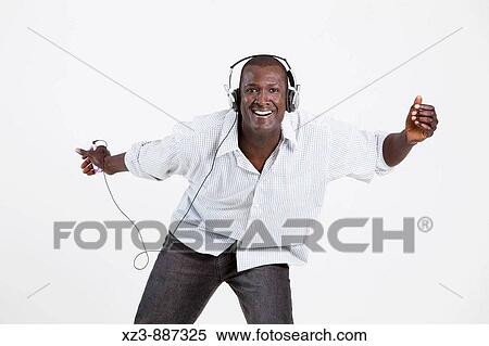 Stock Photography - Portrait of a young black man listening to music and dancing. Fotosearch
