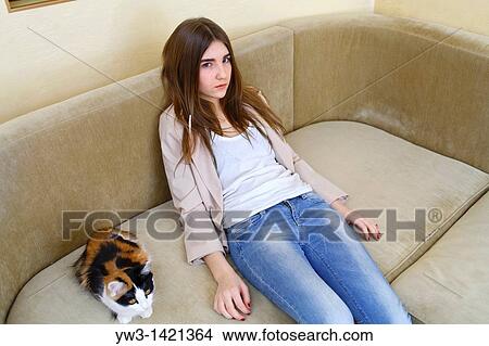 Portrait of a young blond woman in jeans lying on sofa View Large Photo Image Picture - Portrait of a young blond woman in jeans lying on sofa. Fotosearch