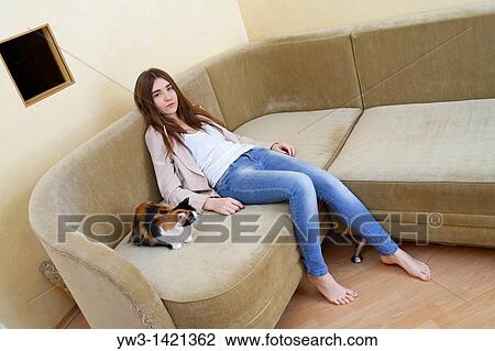 Portrait of a young blond woman in jeans lying on sofa View Large Photo Image Stock Image - Portrait of a young blond woman in jeans lying on sofa. Fotosearch