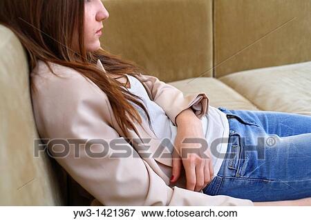 Portrait of a young blond woman in jeans lying on sofa View Large Photo Image Stock Photo - Portrait of a young blond woman in jeans lying on sofa. Fotosearch