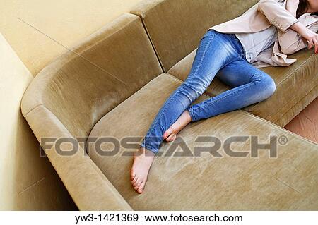 Portrait of a young blond woman in jeans lying on sofa View Large Photo Image Stock Photo - Portrait of a young blond woman in jeans lying on sofa. Fotosearch