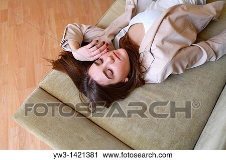 Portrait of a young blond woman lying on sofa View Large Photo Image Stock Image - Portrait of a young blond woman lying on sofa. Fotosearch