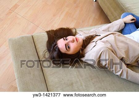 Portrait of a young blond woman lying on sofa View Large Photo Image Stock Photo - Portrait of a young blond woman lying on sofa. Fotosearch