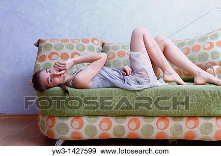 Portrait of a young blond woman lying on sofa View Large Photo Image Stock Photo - Portrait of a young blond woman lying on sofa. Fotosearch