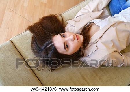 Portrait of a young blond woman lying on sofa View Large Photo Image Stock Photograph - Portrait of a young blond woman lying on sofa. Fotosearch
