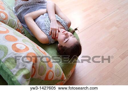 Portrait of a young blond woman lying on sofa View Large Photo Image Stock Photography - Portrait of a young blond woman lying on sofa. Fotosearch