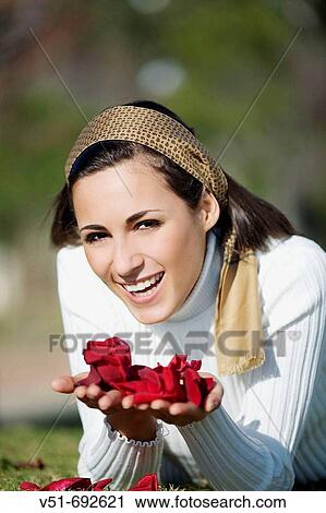 Stock Image - Portrait of a young brunette woman in the park. Fotosearch