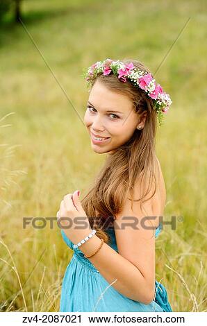 Portrait of a young brunette woman with a floral wreath in her hair outdoors, Germany. View Large Photo Image Stock Image - Portrait of a young brunette woman with a floral wreath in her hair outdoors, Germany.. Fotosearch