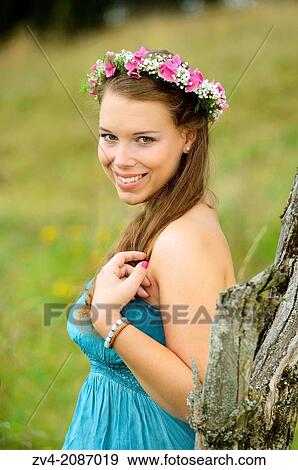 Portrait of a young brunette woman with a floral wreath in her hair outdoors, Germany. View Large Photo Image Stock Photo - Portrait of a young brunette woman with a floral wreath in her hair outdoors, Germany.. Fotosearch