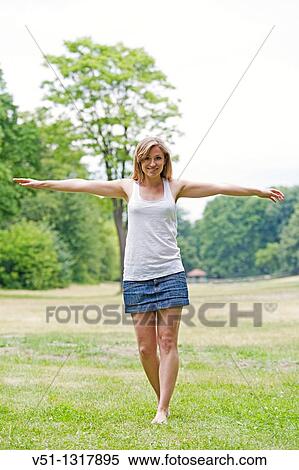 Portrait of a young content woman with arms outstretched in the park View Large Photo Image Stock Photography - Portrait of a young content woman with arms outstretched in the park. Fotosearch
