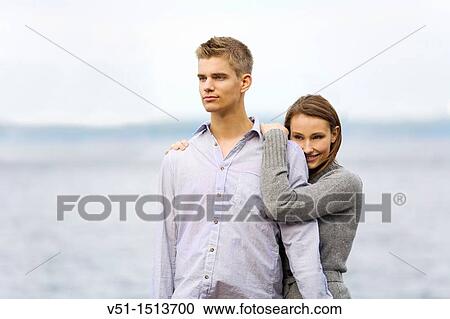 Stock Image - Portrait of a young couple embraced by the sea. Fotosearch