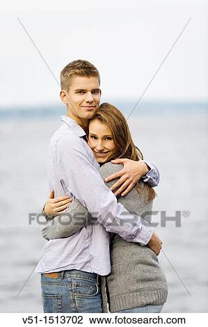 Stock Image - Portrait of a young couple embraced by the sea. Fotosearch