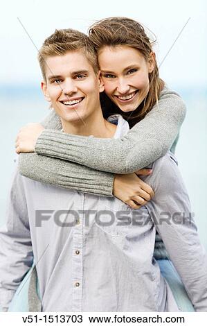 Stock Image - Portrait of a young couple holding by the sea. Fotosearch