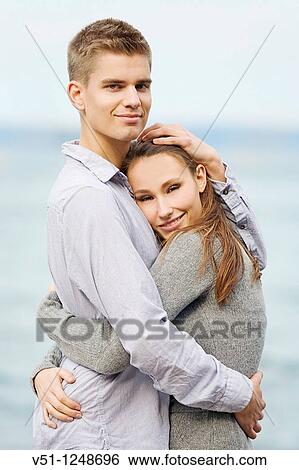 Portrait of a young couple holding by the sea View Large Photo Image Stock Photograph - Portrait of a young couple holding by the sea. Fotosearch