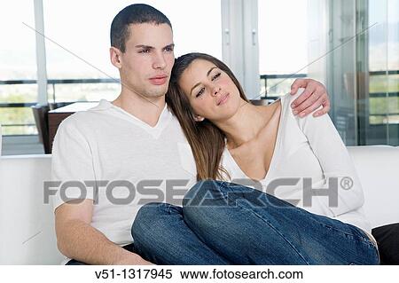 Stock Photography - Portrait of a young couple on the sofa. Fotosearch