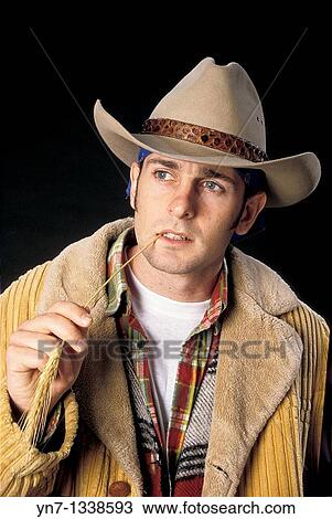 Portrait of a young cowboy in hat and warm jacket sucking on a wheat stalk View Large Photo Image Stock Image - Portrait of a young cowboy in hat and warm jacket sucking on a wheat stalk. Fotosearch
