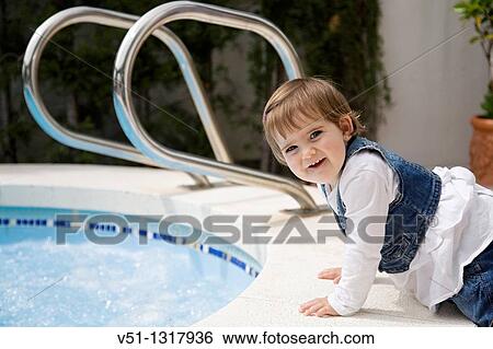 Stock Photograph - Portrait of a young girl by the pool. Fotosearch