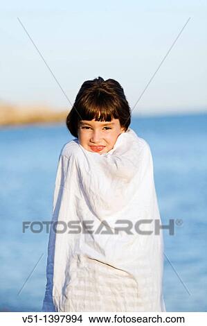 Portrait of a young girl covering with her towel by the sea View Large Photo Image Picture - Portrait of a young girl covering with her towel by the sea. Fotosearch