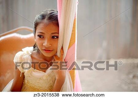 Stock Photo - Portrait of a young girl dressed up for a small village outside of Phnom Penh, Cambodia.. Fotosearch