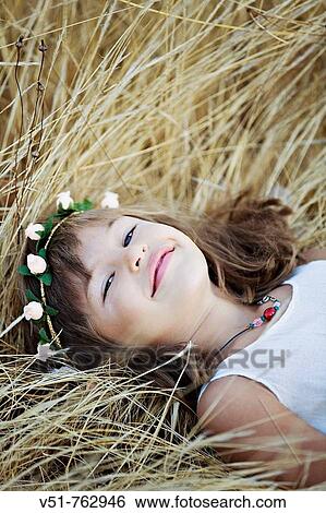 Portrait of a young girl laying in the countryside View Large Photo Image Stock Photograph - Portrait of a young girl laying in the countryside. Fotosearch