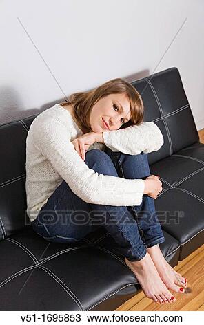 Stock Image - Portrait of a young pretty woman on the sofa. Fotosearch