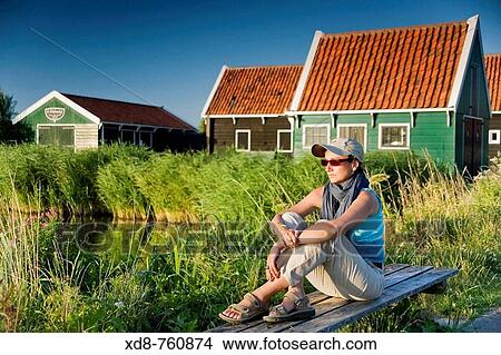 Portrait of a young woman and wooden houses Zaanse Schans, Zaanstad, Zaandam, North Holland province, Holland, Netherlands, Europe View Large Photo Image Picture - Portrait of a young woman and wooden houses Zaanse Schans, Zaanstad, Zaandam, North Holland province, Holland, Netherlands, Europe. Fotosearch