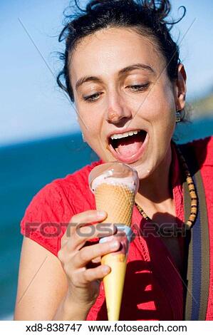 Portrait of a young woman eating a ice cream View Large Photo Image Stock Photo - Portrait of a young woman eating a ice cream. Fotosearch
