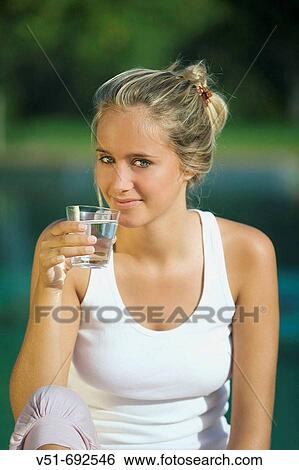 Stock Photograph - Portrait of a young woman holding a glass of water. Fotosearch