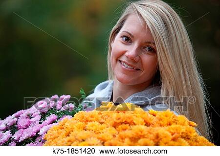 Portrait of a young woman holding mums View Large Photo Image Stock Image - Portrait of a young woman holding mums. Fotosearch