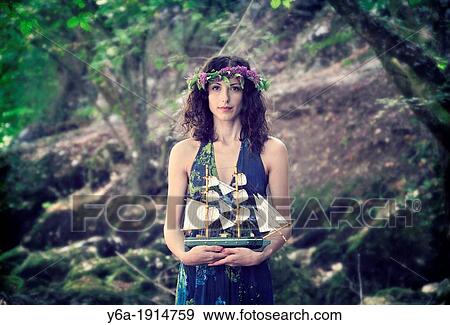 Portrait of a young woman holding toy boat View Large Photo Image Stock Photo - Portrait of a young woman holding toy boat. Fotosearch