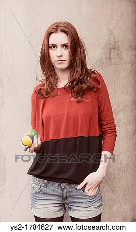 Stock Photo - Portrait of a young woman holding two balls. Fotosearch