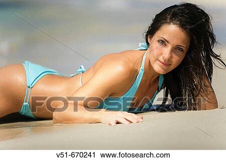 Portrait of a young woman laying down at beach View Large Photo Image Stock Image - Portrait of a young woman laying down at beach. Fotosearch