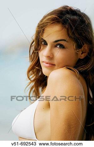 Portrait of a young woman looking at camera on the beach View Large Photo Image Stock Image - Portrait of a young woman looking at camera on the beach. Fotosearch