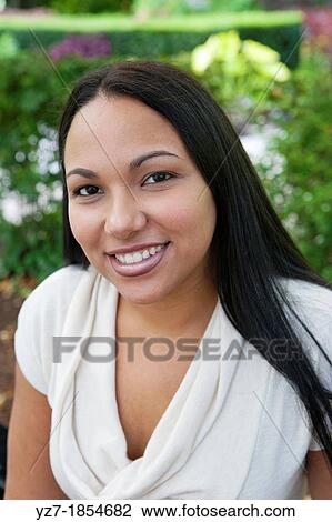 Stock Image - Portrait of a young woman looking into camera. Fotosearch
