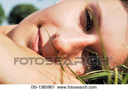 Portrait of a young woman lying in the grass, summer, Germany View Large Photo Image Stock Photo - Portrait of a young woman lying in the grass, summer, Germany. Fotosearch