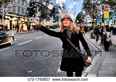 Stock Photo - Portrait of a young woman smiling, Regent Street, London, England. Fotosearch