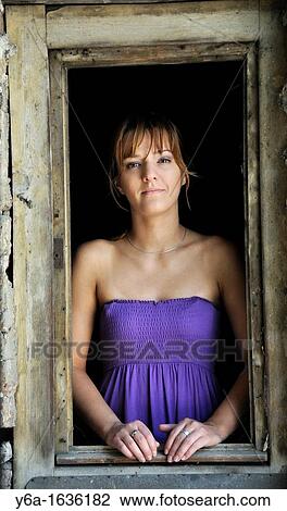 Portrait of a young woman standing in window frame View Large Photo Image Stock Image - Portrait of a young woman standing in window frame. Fotosearch