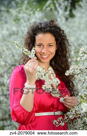 Portrait of a young woman standing beside a flowering tree, Germany View Large Photo Image Picture - Portrait of a young woman standing beside a flowering tree, Germany. Fotosearch