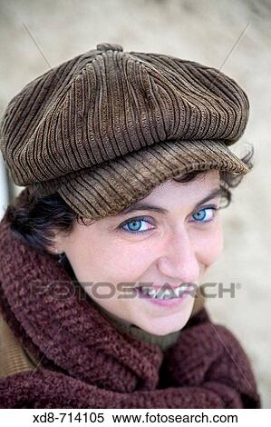 Stock Photography - Portrait of a young woman with blue eyes and a velveteen cap smiling. Fotosearch